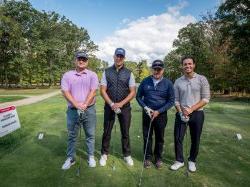 Four men standing on golf course