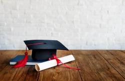标题图像的毕业帽和奖项在一个白色的砖背景前.